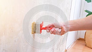 A man applies wallpaper glue with brush for wallpapering. Repair of a room, apartment, house.