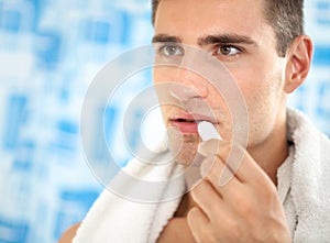 Man applying balsam for lips