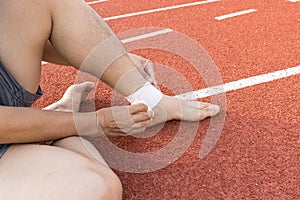 Man applying compression bandage onto ankle injury