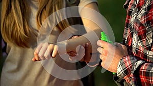 Man applying cooling cream on ladys arm after mosquitoes bite, insect repellent