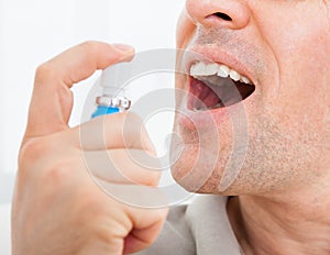 Man applying fresh breath spray photo