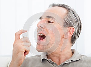 Man applying fresh breath spray