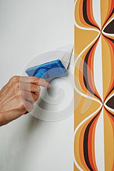 man applying glue to the wall with a pasting brush