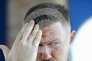 Man applying hair gel to his hair closeup