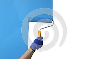 Man applying light blue paint with roller brush on white wall, closeup