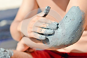 Man applying mineral blue mud on elbow