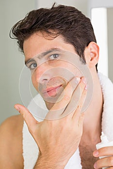 Man applying moisturizer on face