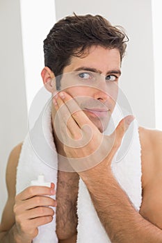 Man applying moisturizer on his face