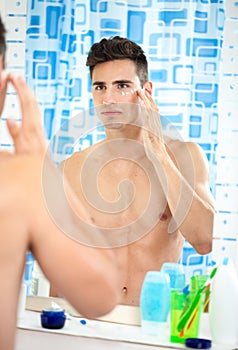 Man applying moisturizer on his face photo