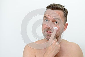 Man applying moisturizer to his skin