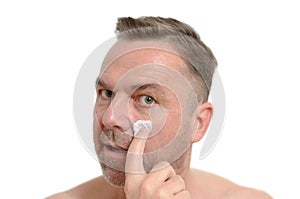 Man applying moisturizer to his skin