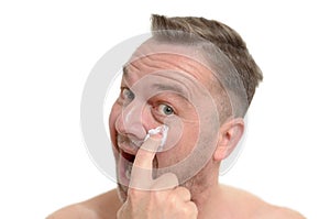 Man applying moisturizer to his skin