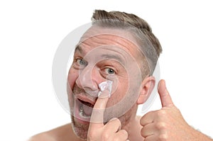 Man applying moisturizer to his skin