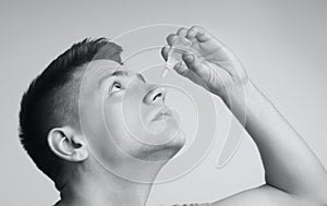 Man applying ophthalmology eyedropper, black and white photo