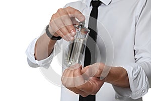 Man applying perfume on wrist against white background