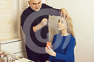 Man applying powder on girl face skin with makeup brush