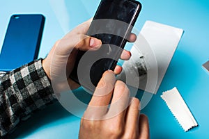 Man applying protective tempered glass to phone screen