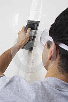 Man Applying Putty On Wall photo