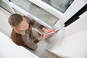 Man Applying Silicone Sealant With Gun photo