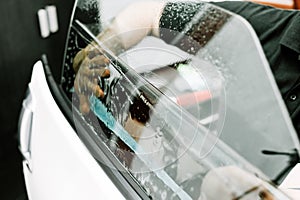 Man applying tinting film on the car window