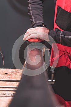 Man applying wax or parrafin onto freshly serviced pair of alpine skis. Thorough service of skis in a workshop