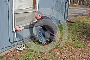 Man applying weather stripping in Fall