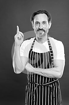 Man in apron. Confident mature handsome man in apron red background. He might be baker gardener chef or cleaner. Good in