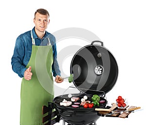 Man in apron cooking on barbecue grill