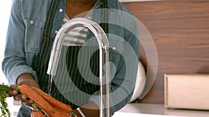 Man with apron washing vegetables