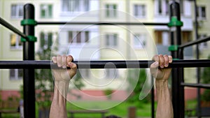 A man of Arab appearance on pull -up bars does exercises. Fitness Sport Street training. Muscles in the public gym.