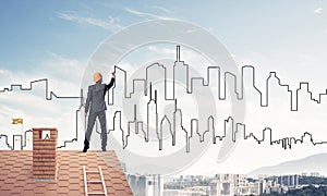 Man architect draw silhouette of modern city on blue sky. Mixed