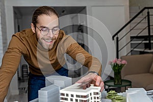 Man architect working in office on creation of new residential complex designing layout of buildings