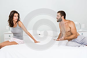 Man arguing with woman on bed