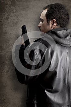 Man armed with gun on black textured background