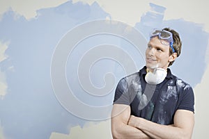 Man With Arms Crossed Against Incomplete Painted Wall