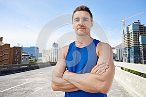 Man, arms crossed in city and fitness outdoor with workout, training and athlete in portrait for sports. Confidence