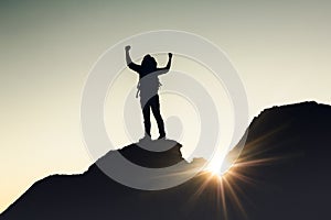 Man with arms raised at sunset