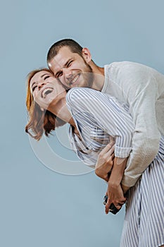 Man with artificial limb hugs his girlfriend from the back and they are laughing