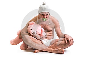 Man as baby. Child in diaper with pink teddy bear.