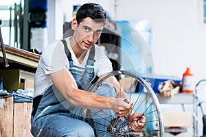 Man as bicycle mechanic working in workshop