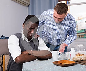 Man asking for forgiveness from offended African friend