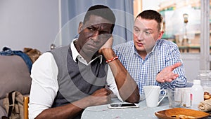 Man asking for forgiveness from offended African friend