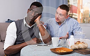 Man asking for forgiveness from offended African friend