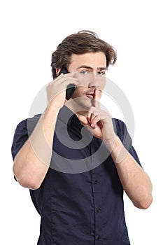 Man asking for silence with finger on lips while is calling on the phone