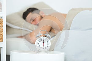 man asleep in bed alarm clock ready six oclock