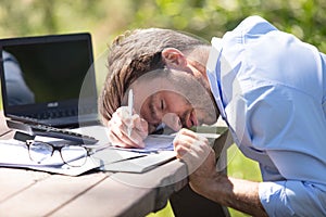 man asleep at outdoor desk