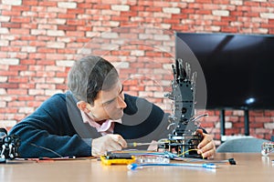 Man Assembles Bionic Hand Prototype, Robotics Engineer Working on Advanced Prosthetic Arm, Scientist Developing Robotic Limb,