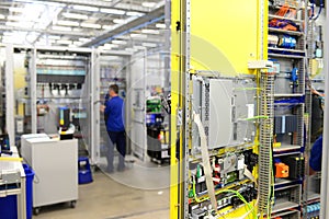 man assembles electronic components on a machine in a factory for mechanical engineering