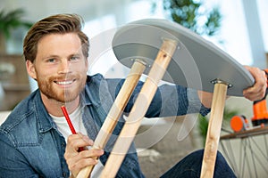 man assembles furniture at home photo