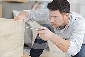 Man assembles furniture wardrobe photo